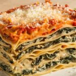 Creamy Spinach Mushroom Lasagna 7 A serving of creamy spinach mushroom lasagna with layers of spinach, mushrooms, and creamy white sauce topped with melted cheese.