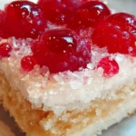 Raspberry Swirl Coconut Snowball Cake 7 A slice of Raspberry Swirl Coconut Snowball Cake with raspberry swirl and shredded coconut topping on a white plate.