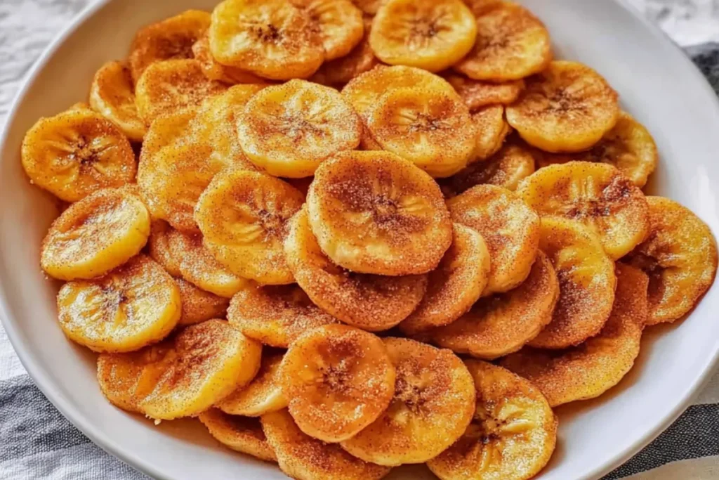 Sweet Cinnamon Air Fryer Banana Chips in a bowl, crispy and golden with a dusting of cinnamon sugar, served as a healthy snack.