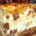 Pecan Pie Lasagna 7 A delicious slice of Pecan Pie Lasagna with layers of graham cracker crust, cream cheese filling, pecan pie topping, and caramel drizzle.