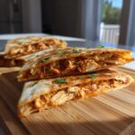 Close-up of sliced 3-Ingredient BBQ Chicken Quesadillas on a wooden board, showing the filling.