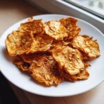 Close-up of a plate of delicious Baked Apple Cinnamon Oat Chips, sprinkled with oats.