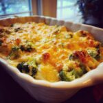 Close-up of a freshly baked Broccoli Cheese Casserole in a white baking dish.