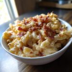 A bowl of creamy Ultimate Cheesy Bacon Mac and Cheese topped with crispy bacon.