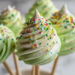 Close-up of green Christmas Tree Meringue Pops decorated with sprinkles.