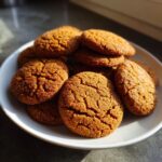 A white plate piled high with Classic Gingerbread Cookies Soft & Chewy, glistening with sugar.