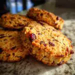 Close-up of delicious Cranberry Orange Shortbread Cookies, showing dried cranberries studded throughout the golden baked cookie.