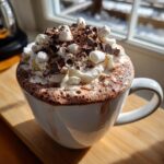 A delicious mug of hot chocolate topped with whipped cream, marshmallows, and chocolate shavings, perfect for a DIY Hot Chocolate Bar Setup.