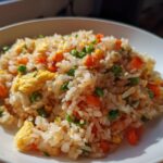 A bowl of Easy Veggie Fried Rice with Egg, featuring rice, vegetables, and scrambled egg.