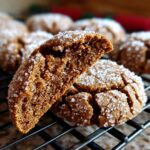 A close-up of soft Gingerbread Crinkle Cookies, one broken in half to show the texture, coated in sugar.