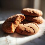 A close-up of two delicious Gingerdoodle cookies, one broken in half, coated in sparkling sugar.