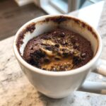 Close-up of a Greek Yogurt Chocolate Peanut Butter Mug Cake in a white mug.