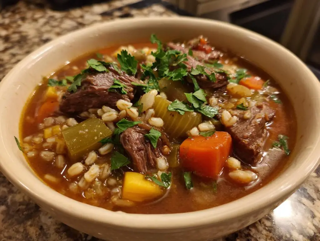 Close-up of a bowl of Hearty Beef & Barley Soup with beef chunks, barley, and vegetables.