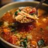 Close-up of a spoonful of High-Protein Turkey & Quinoa Soup, showing quinoa, turkey, and vegetables.