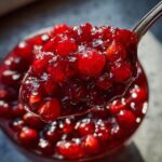 Close-up of a spoonful of Homemade Cranberry Sauce, showing the texture and color.