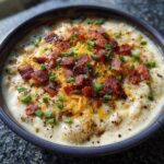 Close-up of a bowl of Loaded Baked Potato Soup topped with bacon, cheese, and chives.