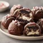 Close-up of Peppermint Bark Stuffed Oreo Balls, showing the creamy filling and chocolate coating.