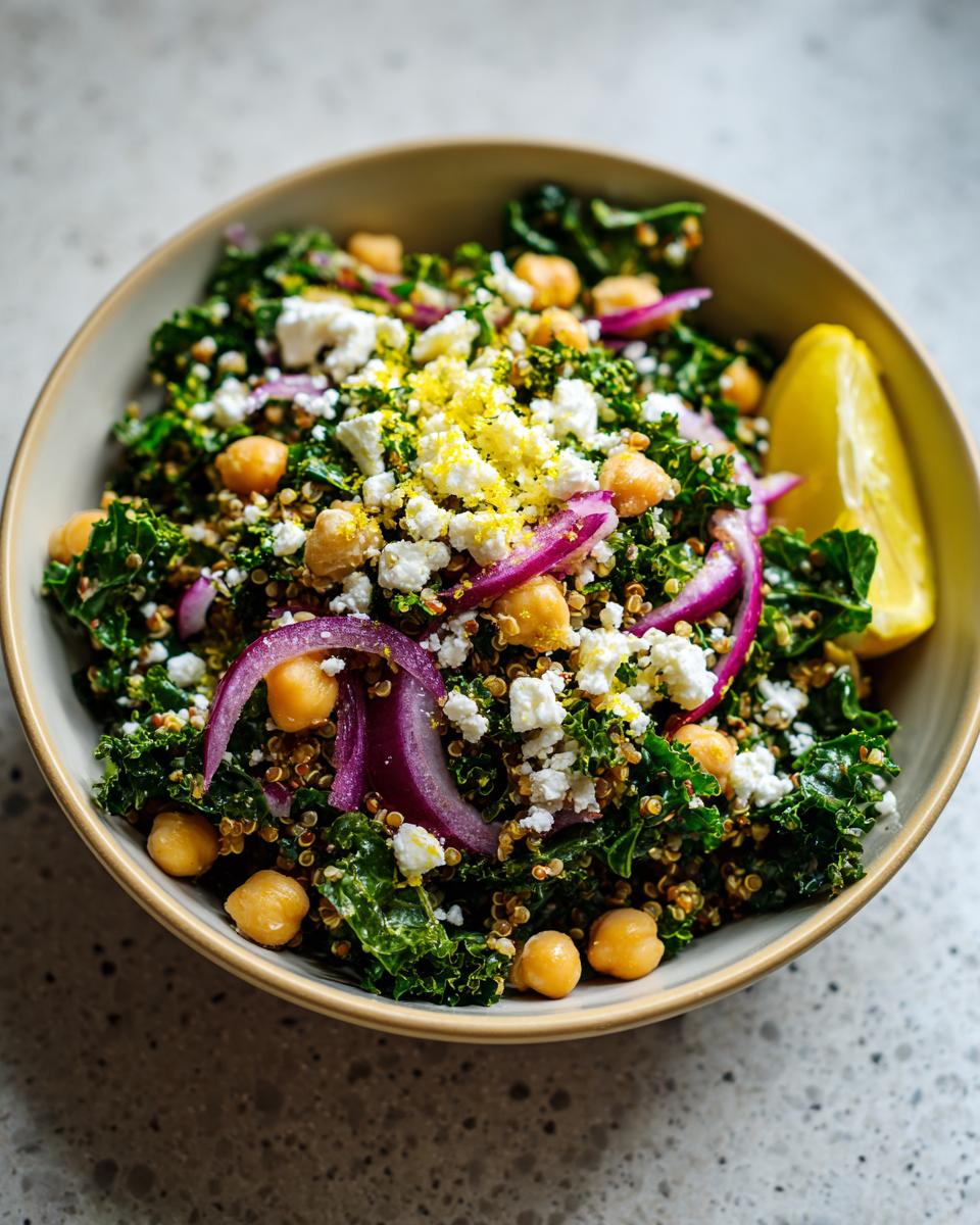 Close-up of a Quinoa Kale Power Bowl with kale, quinoa, chickpeas, red onion, and lemon wedge.