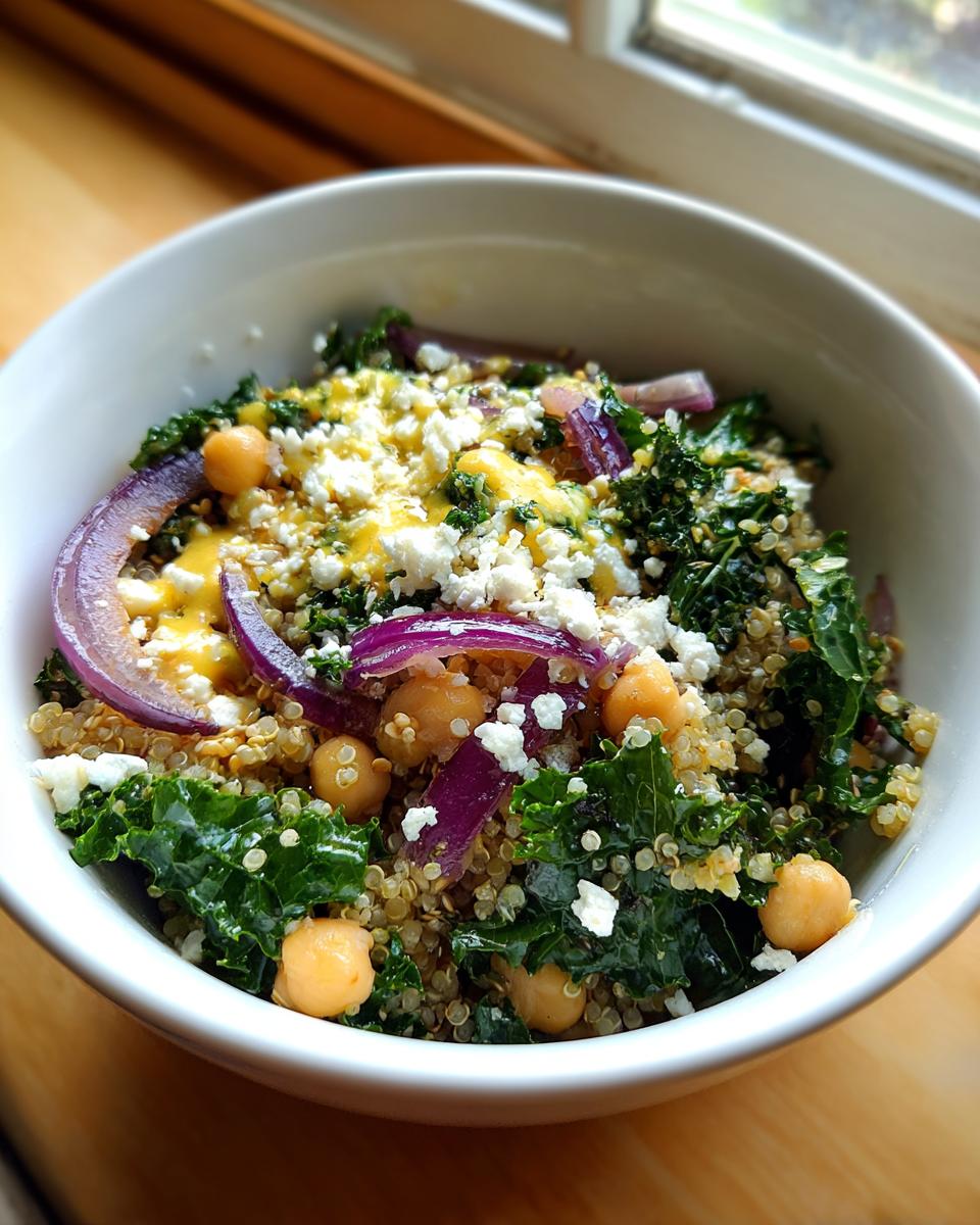 A vibrant Quinoa Kale Power Bowl with lemon vinaigrette, kale, quinoa, chickpeas, and red onion.