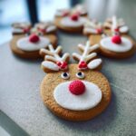 Close-up of decorated Rudolph the Red-Nosed Reindeer sugar cookies with white icing and red candy noses.