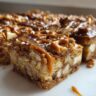 Close-up of Salted Caramel Pretzel Blondies with caramel drizzle and sea salt.
