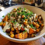 Close-up of a Spiced Chickpea and Sweet Potato Buddha Bowl with tahini dressing and pumpkin seeds.