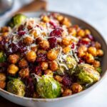 Close-up of a bowl of Spicy Roasted ChickpeasBrussels Sprout Salad with cranberries and parmesan cheese.