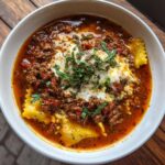 Close-up of a bowl of Easy Lasagna Soup with meat sauce, cheese, and herbs.