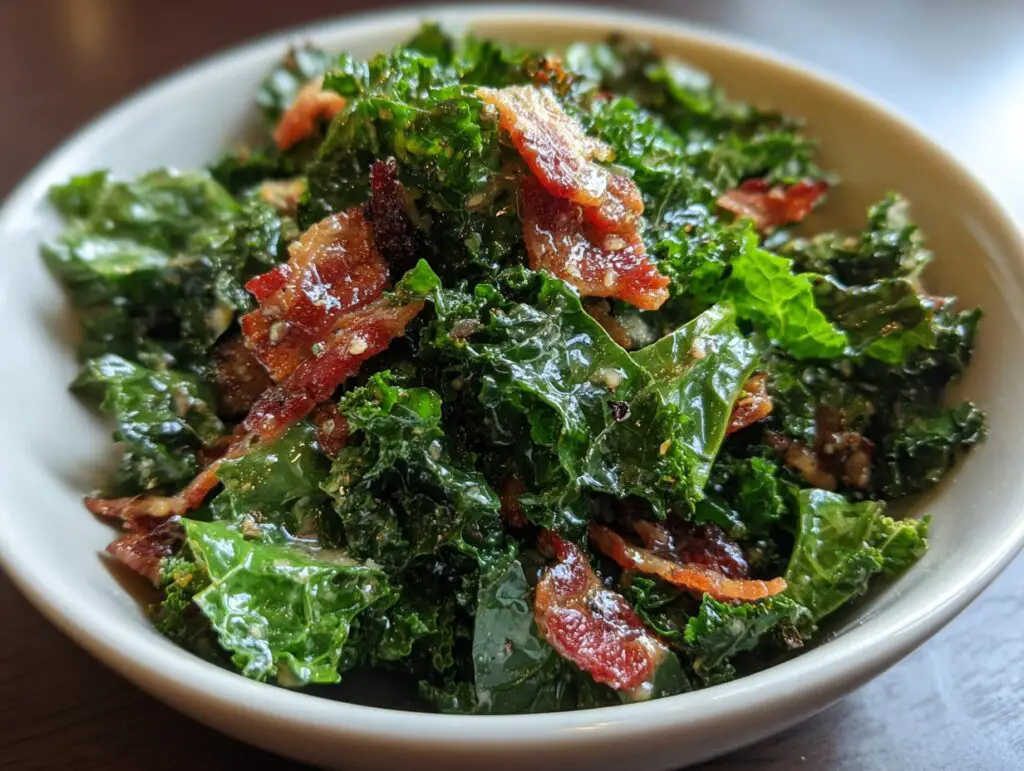 Close-up of a delicious Kale and Bacon Salad in a white bowl, showing fresh kale and crispy bacon.