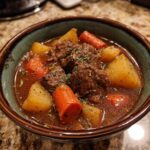 Close-up of a bowl filled with delicious Old Fashioned Beef Stew, carrots, and potatoes.