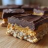 Close-up of a layered No Bake Dessert bar with a chocolate topping.