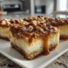 Close-up of Caramel Pecan Cheesecake Bars with a shortcut crust, drizzled with caramel and topped with pecans.