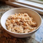 A white bowl filled with a homemade chicken and rice cat meal.
