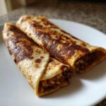 Two golden-brown Chocolate Crunchy Wraps on a white plate, ready to eat.