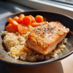 A bowl of Fresh Fish Cat Bowl featuring cooked salmon, rice, and carrots.