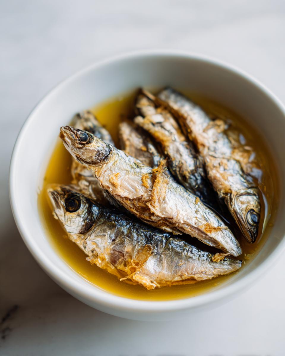 Amazing Fresh Sardine Cat Dinner: 1 Happy Cat 7 Close-up of fresh sardines in a white bowl, ready for a Fresh Sardine Cat Dinner.