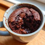 Close-up of a fudgy microwave brownie in a mug, perfect for a quick dessert. Featuring the Easy Recipe: Make a Fudgy Microwave Brownie.