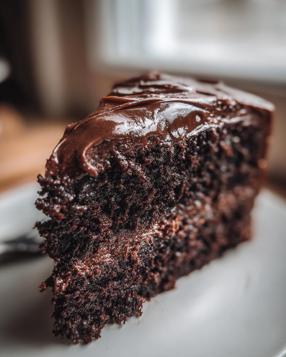 Close-up of a slice of Guinness Chocolate Cake with Irish Buttercream on a white plate.