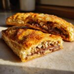 Close-up of a Puff-Pastry Chocolate Crunch Wrap, cut open, showing chocolate and crispy filling.