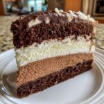 Close-up of a slice of Triple Chocolate Mousse Cake, showing layers of chocolate cake and mousse.