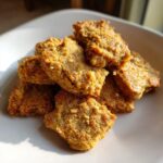 Tuna & Oat Cat Crunchies: Irresistible 15-Min Treat 11 Close-up of a pile of golden-brown Tuna & Oat Cat Crunchies on a white plate.