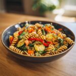 Amazing Asian Pasta Salad: 1 Flavor Bomb 11 Close-up of a bowl of delicious Asian pasta salad with vegetables and sesame seeds. The pasta salad asian is ready to eat.