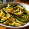 Close-up of a bowl of asparagus and zucchini pasta salad.