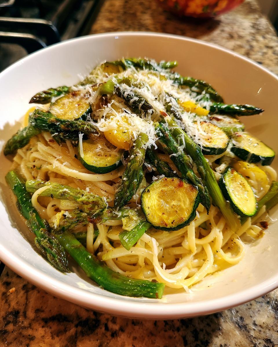 Amazing Asparagus Zucchini Pasta Salad: 1 Delicious Bite 3 Close-up of a bowl of asparagus and zucchini pasta salad, topped with cheese.