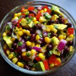 Close-up of a bowl of Avocado Corn Black Bean Salad, a colorful and healthy dish.