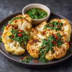 Delicious roasted cauliflower steaks topped with fresh chimichurri sauce. A flavorful vegetarian dish, the perfect Cauliflower Steaks with Chimichurri.