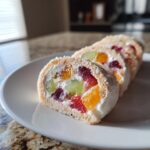 Close-up of sliced Cheesecake Fruit Salad Roll Ups, showing fruit filling and cream.