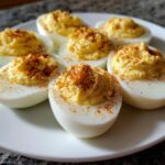 Amazing Classic Deviled Eggs: 6 Perfect Yolks 11 Close-up of classic deviled eggs on a white plate, topped with paprika.
