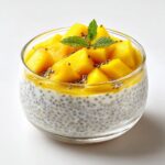 Close-up of a Coconut Chia Pudding with Mango, topped with fresh mango chunks and mint.