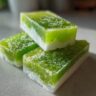 Close-up of three layered Coconut Lime Popsicles, showing the green and white layers.
